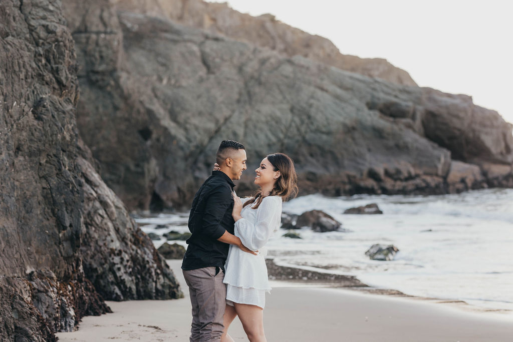 couples posing for photos on china beach in san francisco california 