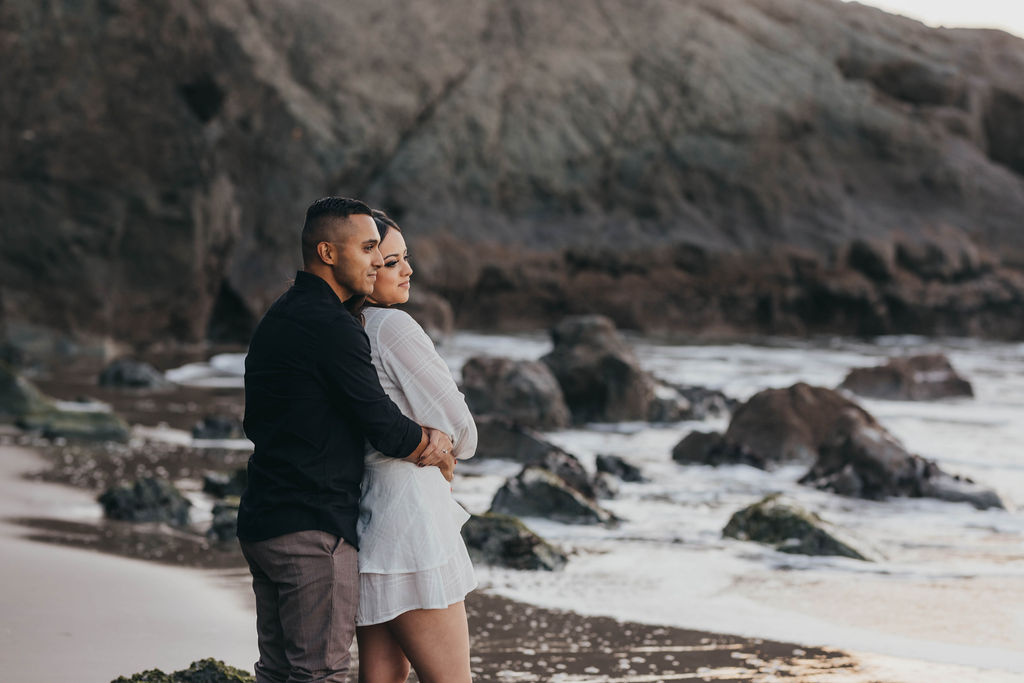 man and woman holding eachother for romantic beach photoshoot
