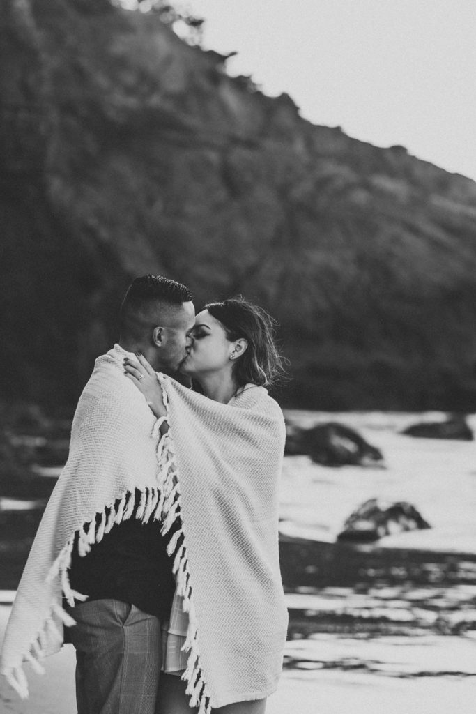Couple posing on beach for engagement photoshoot beach session