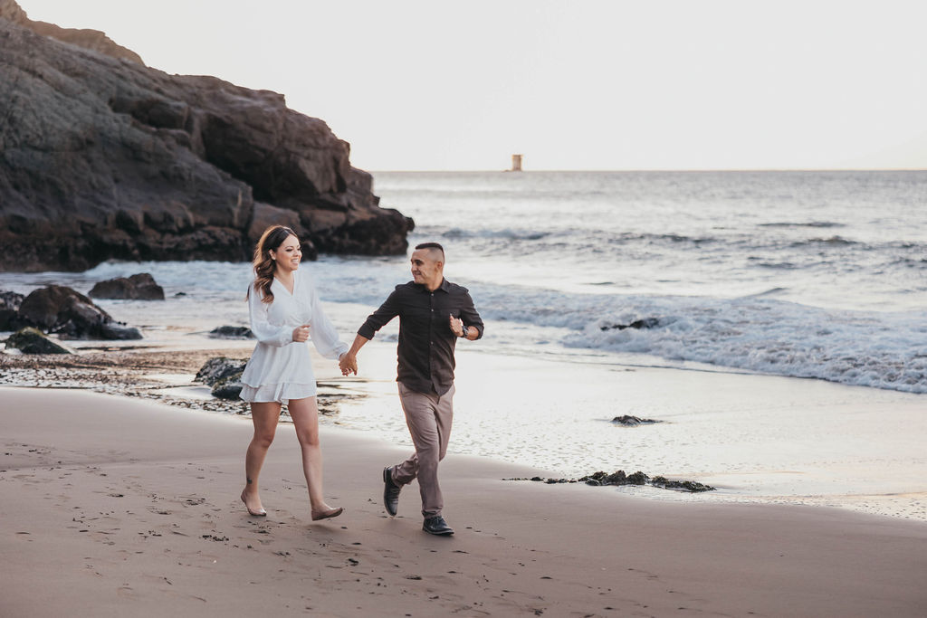 man and woman running along the beach shorline