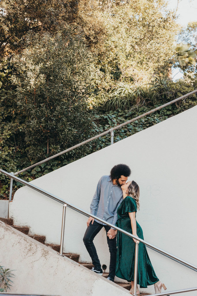 Couple kissing on stairs for engagement photos in Oakland CA Merritt Lake