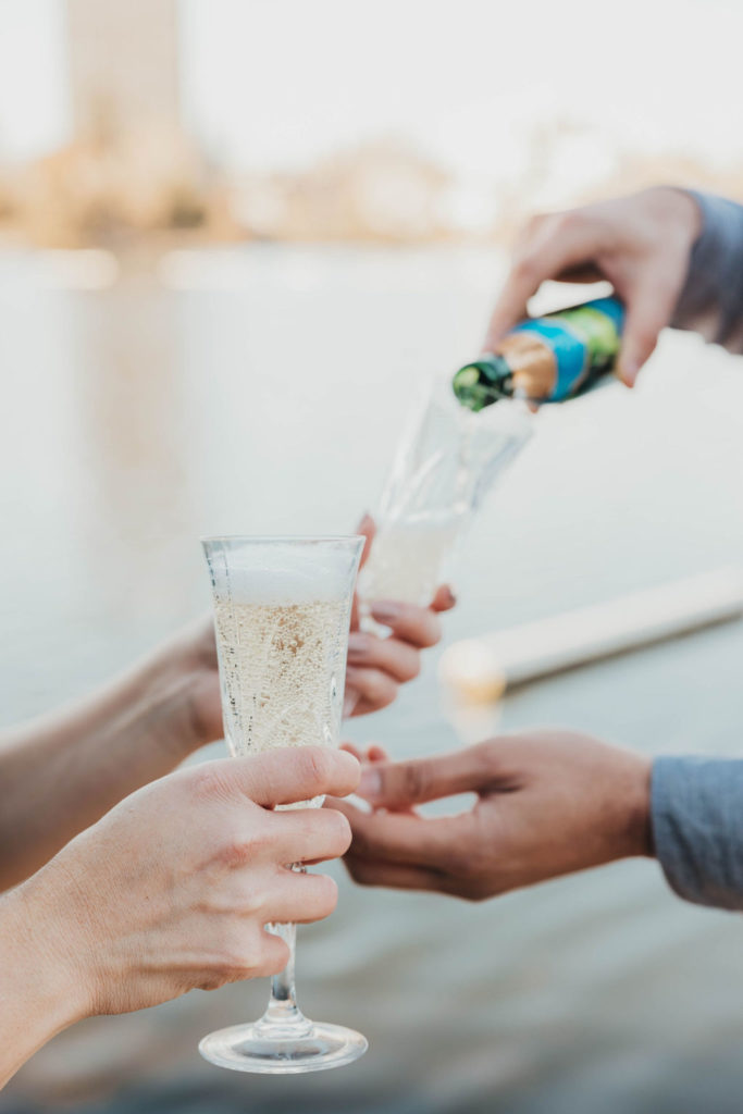 Couple pouring champagne for engagement photoshoot