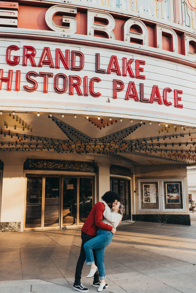 Couple kissing in front of historic Grand Lake theatre