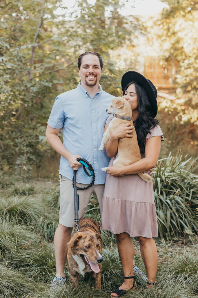 Couple posing for engagement photos with dogs