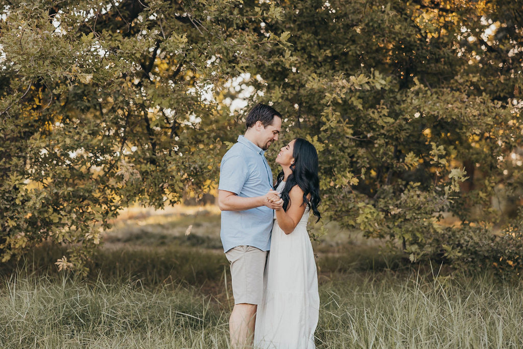 Couple posing for summer engagement photos at Ruth Risdon Storer Garden in Davis California University