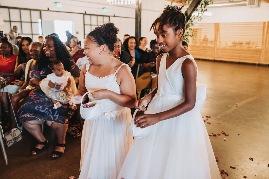 Flower girls walking down the aisle for wedding in CA