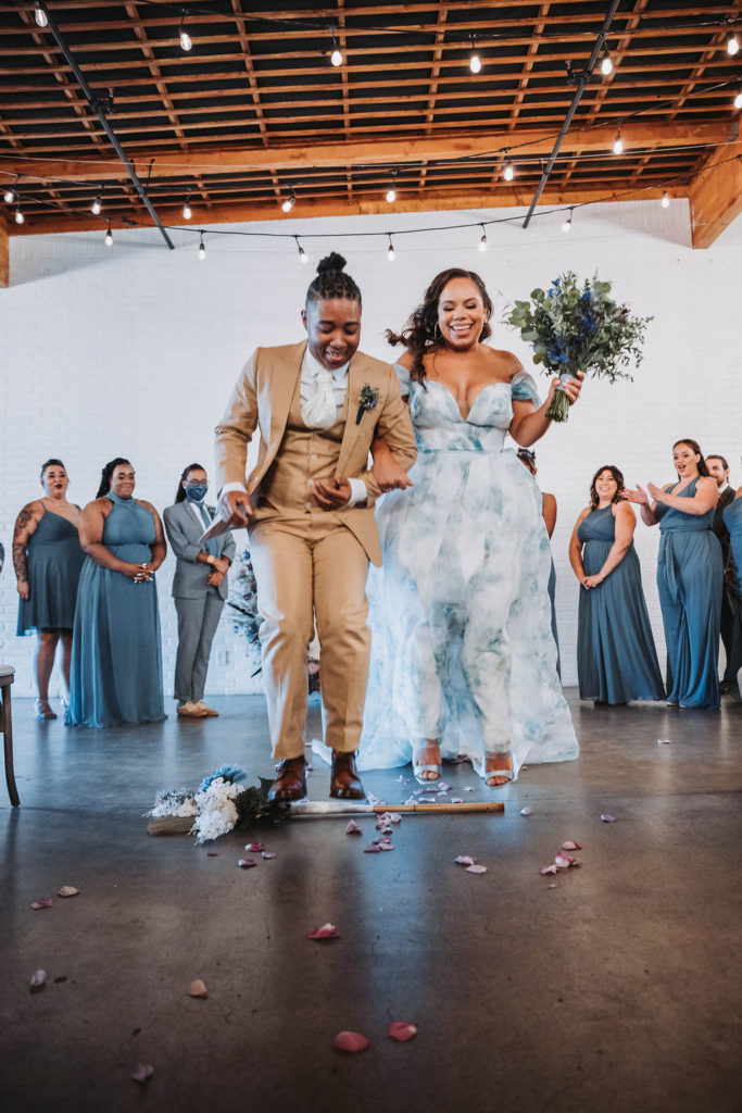 Couple jumping the broom during wedding in CA