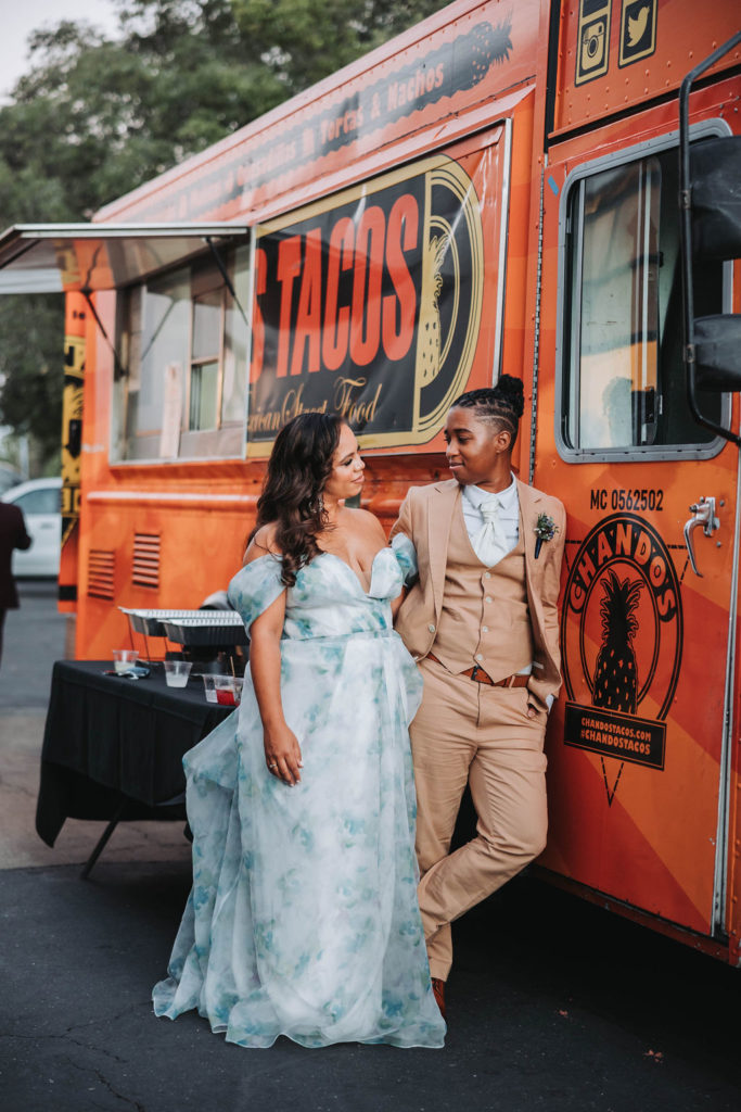 Couple loeaning against Taco truck at wedding reception