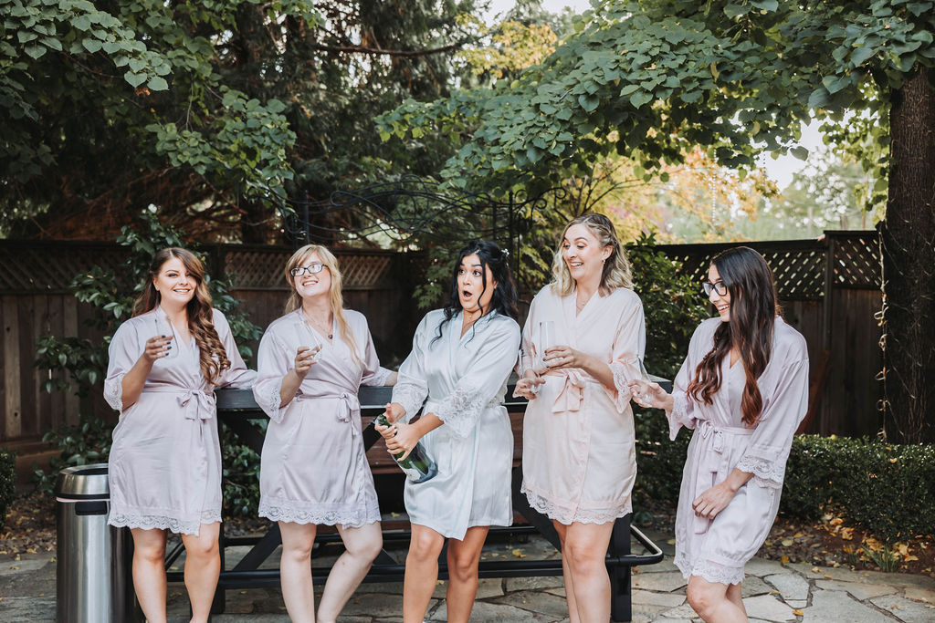 Bride and bridesmaids popping champagne