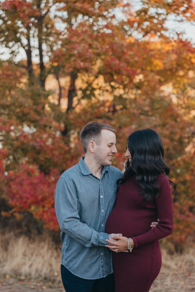 Couple posing for fall maternity photos at Coyote Pond in Lincoln, California