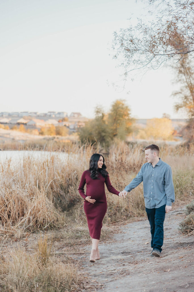 Couple posing for fall maternity photos at Coyote Pond in Lincoln, California