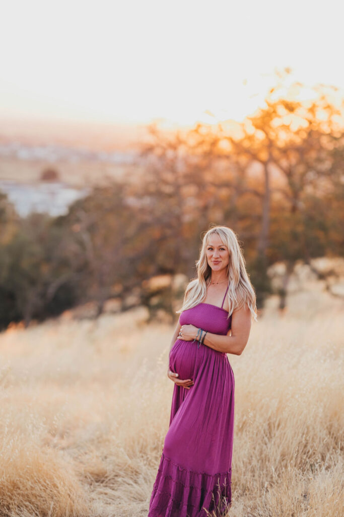 Pregnant woman holding her belly for photos