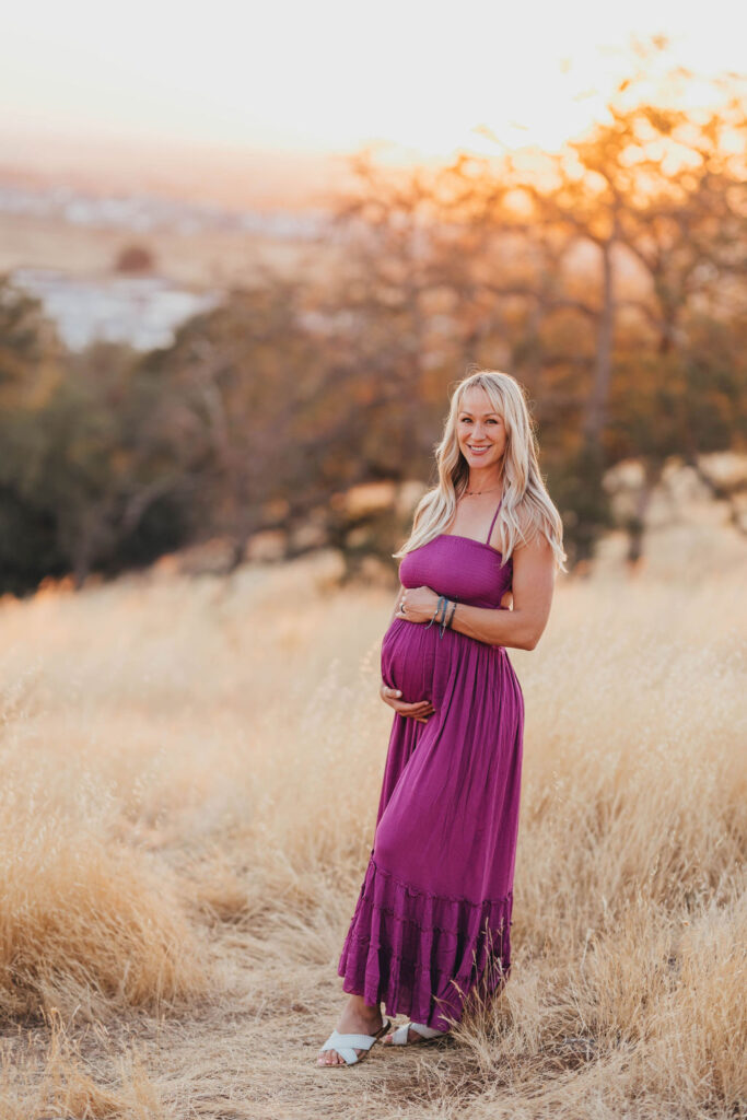 Pregnant woman holding her belly for photos