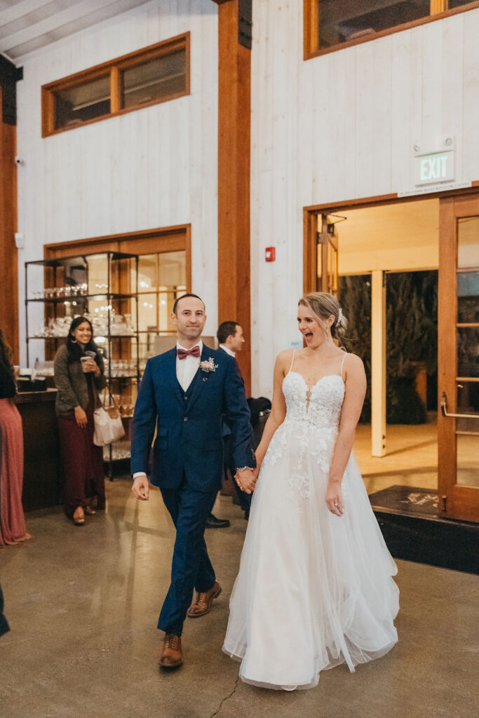 Bride and groom entering indoor reception space