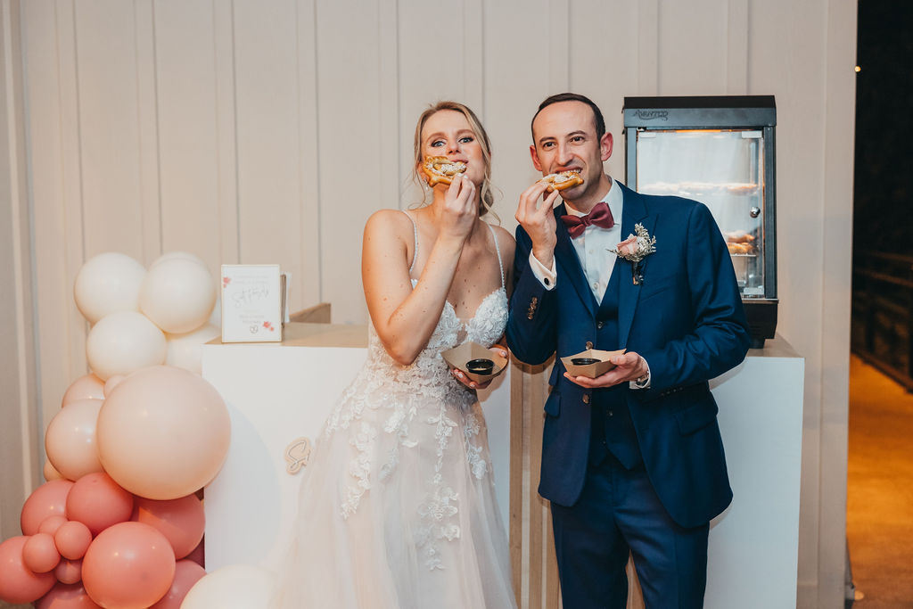 Bride and groom eating pretzels