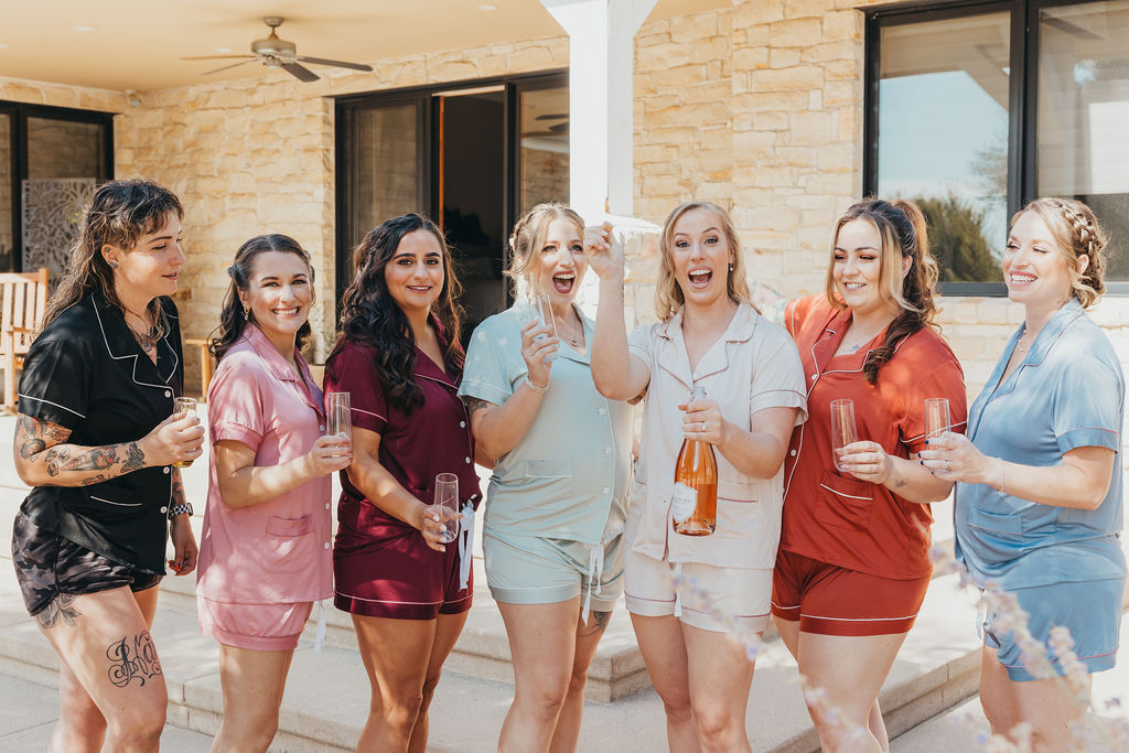 Bride and bridesmaids popping champagne 