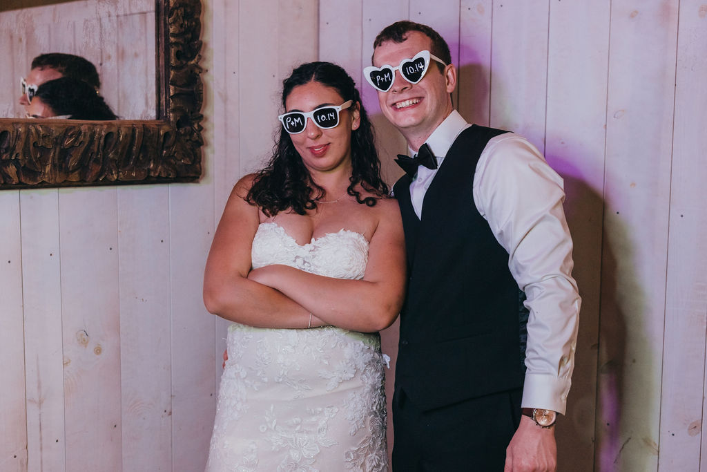 Bride and groom wearing heart shaped sunglasses