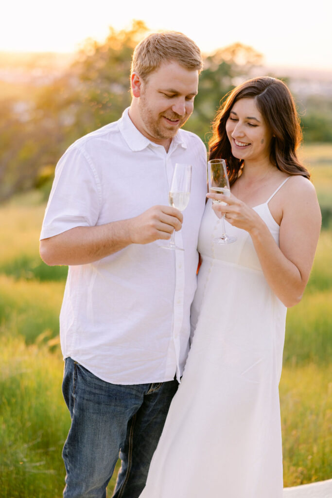 Romantic golden hour photo of engaged couple embracing in a field near Sacramento, CA