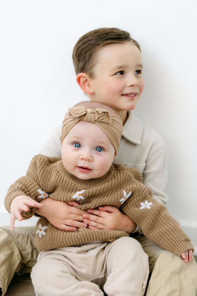 Family sharing a candid moment during a relaxed indoor photoshoot.
