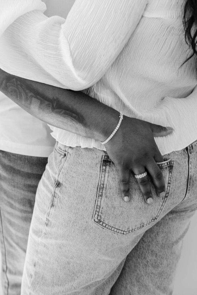 Candid moment of couple holding hands and smiling at each other indoors
