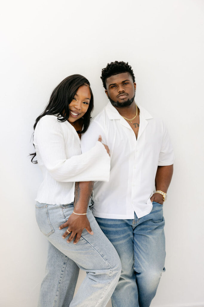 Candid moment of couple holding hands and smiling at each other indoors
