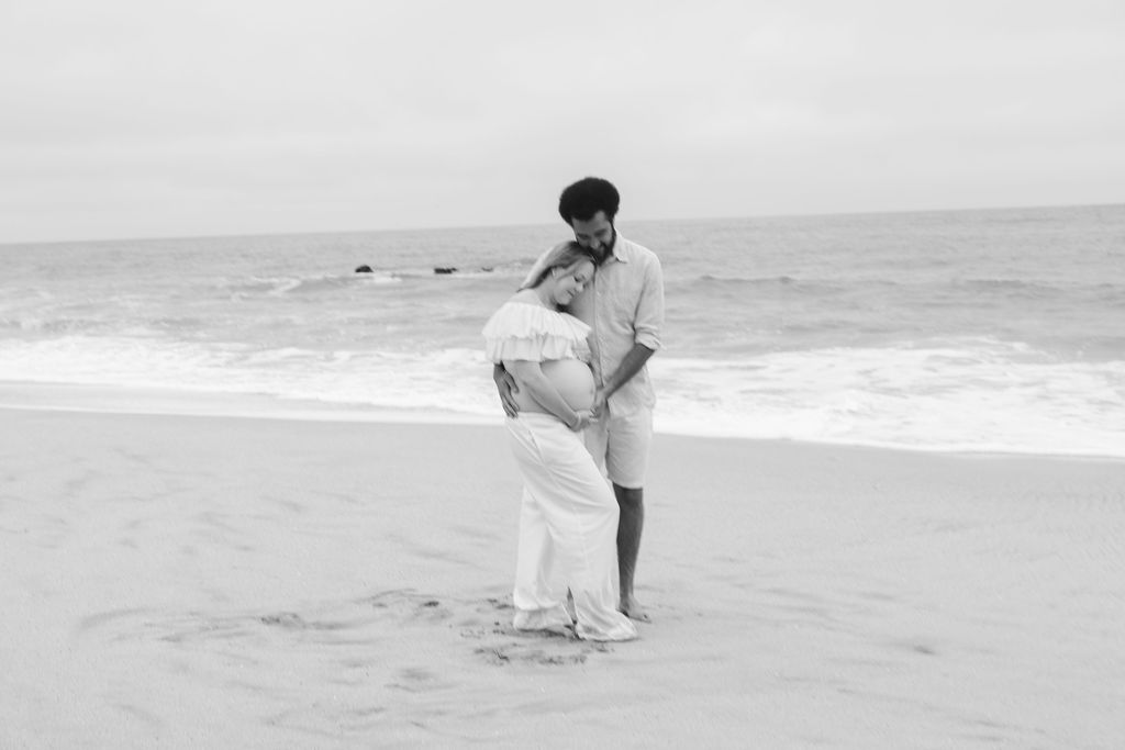 Candid moment of a couple laughing together with cliffs and the Ritz-Carlton in the distance 
