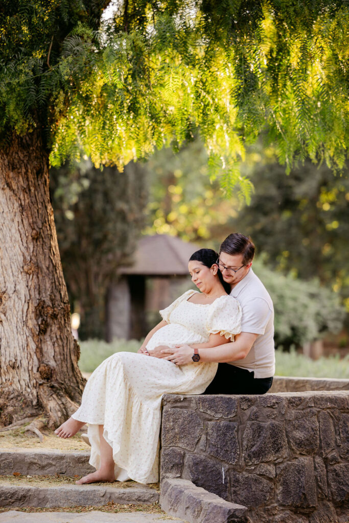 Couple embracing during outdoor maternity photography shoot
